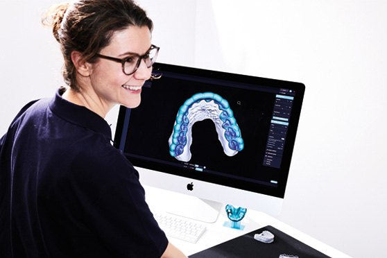 Een medewerkster van het laboratoriumwerkt met de DentaMile connect-software